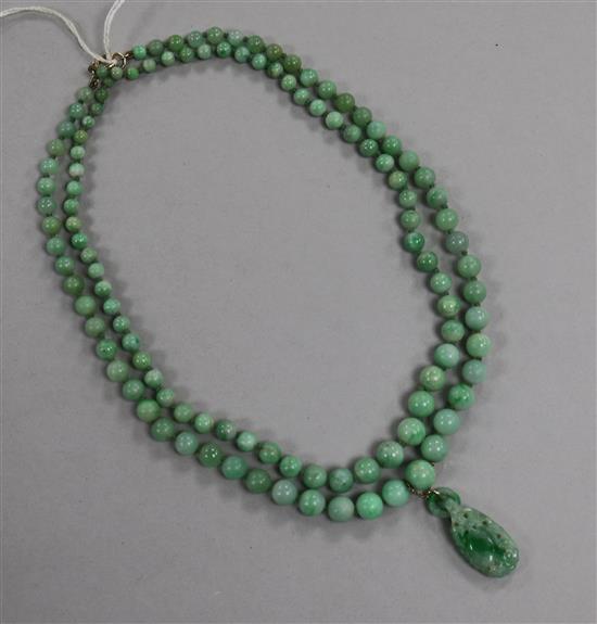 A double strand graduated jadeite bead necklace with carved jadeite pendant, pendant 29mm.